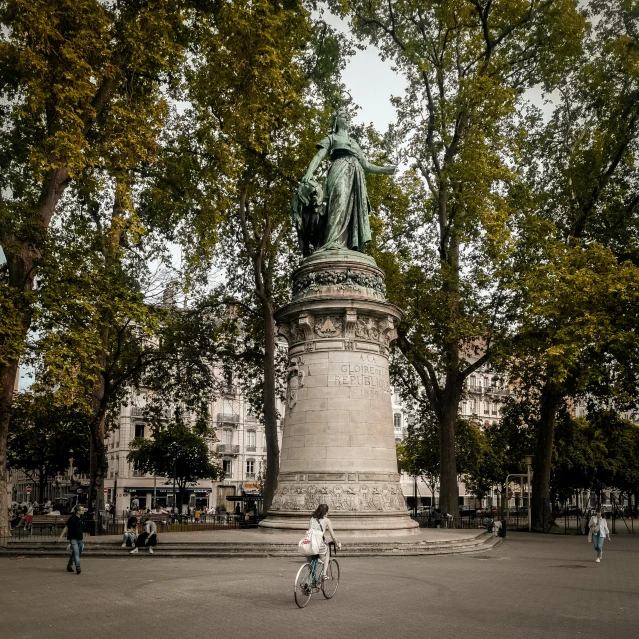 some people riding bikes and a statue in the middle