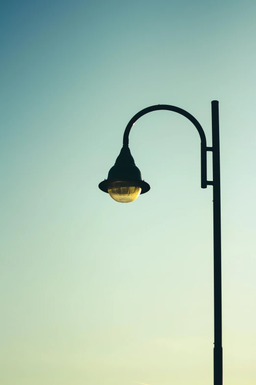 the street light is shining in the evening sky