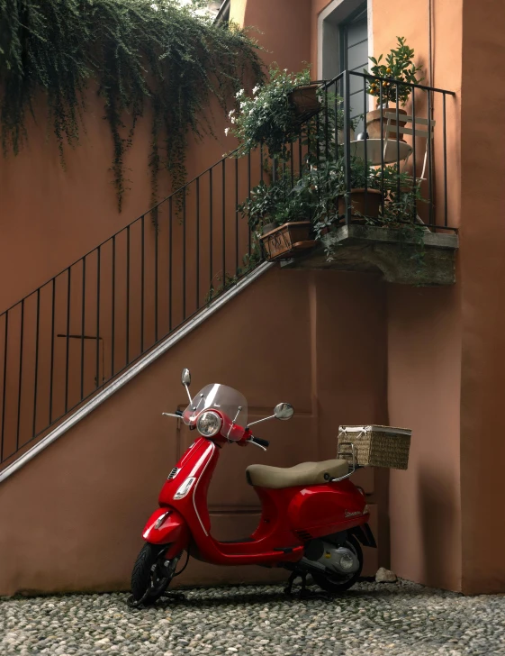 a red scooter parked on the side of a building