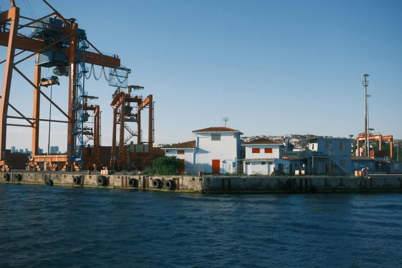 a harbor scene with houses, a crane and buildings