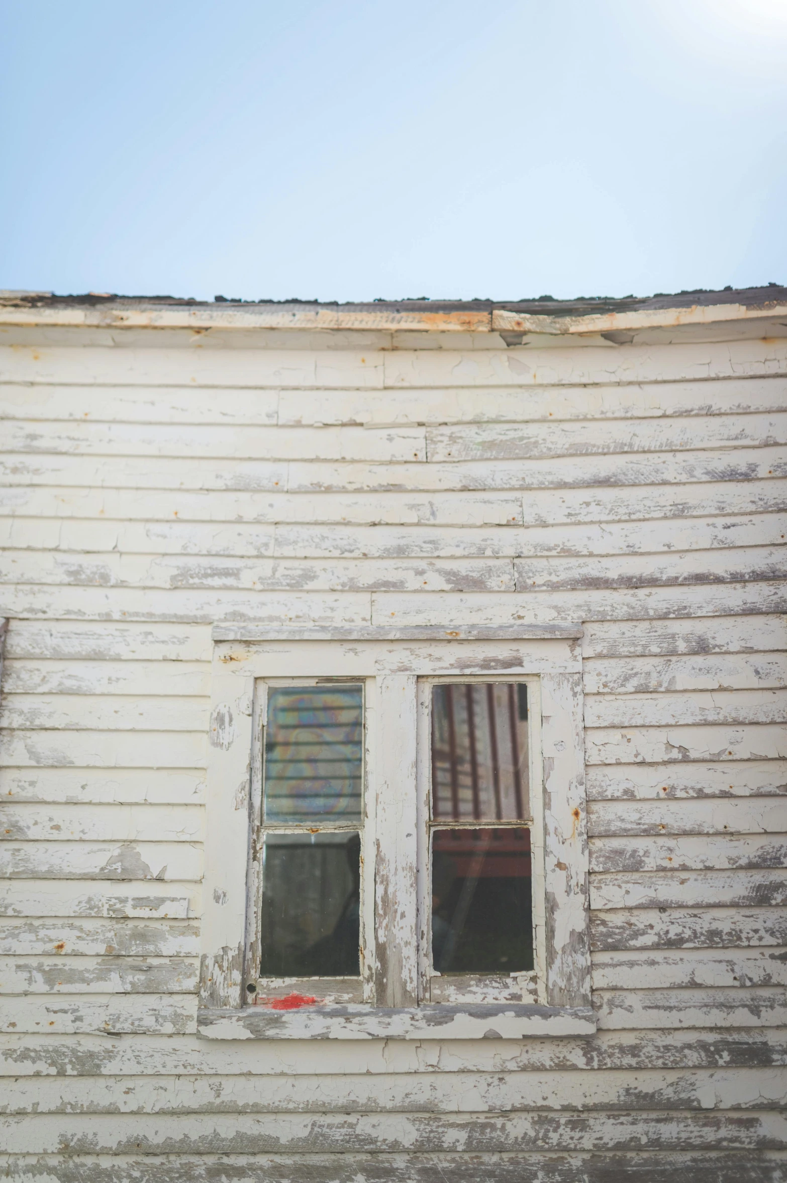 an abandoned white building with two windows