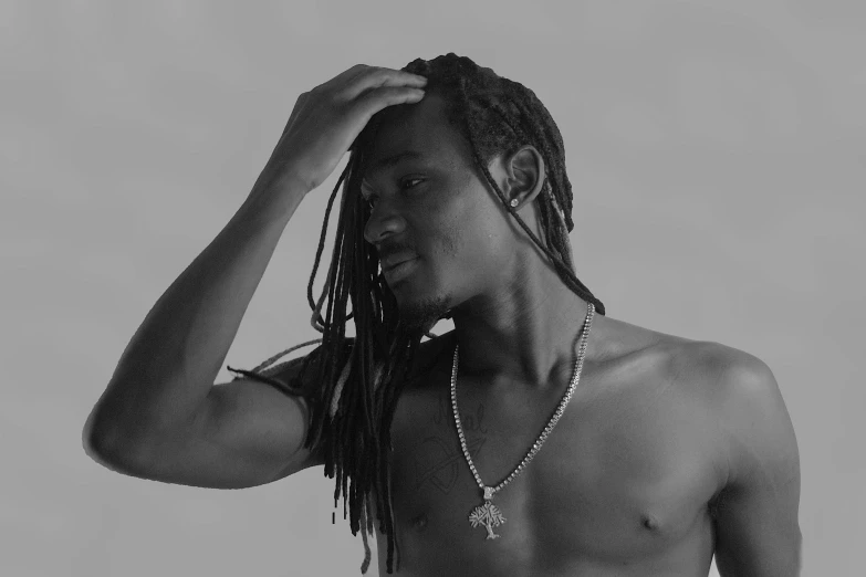 a young man with dread locks holding up his shirt