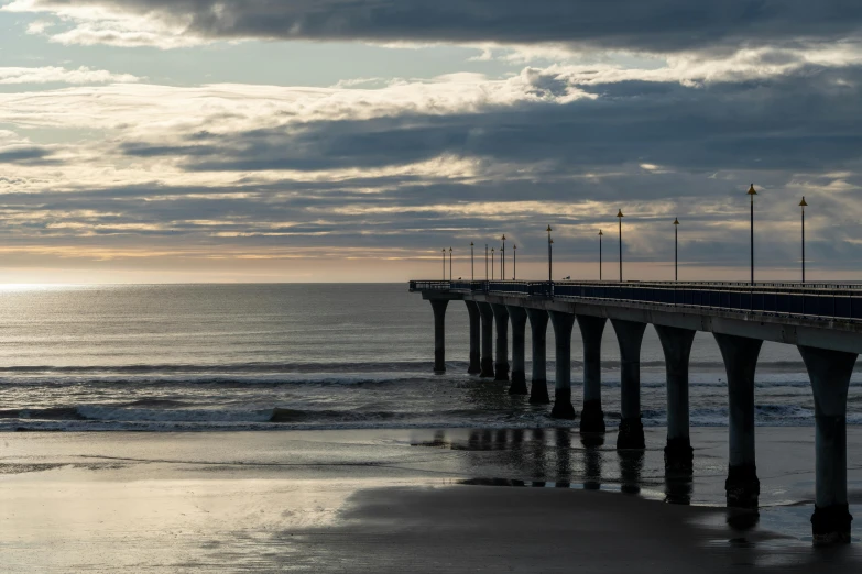 the ocean is in front of the long pier