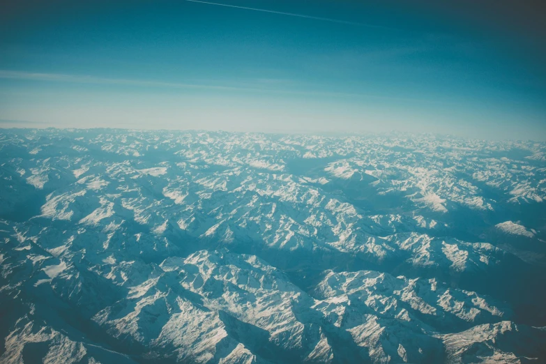 the view from an airplane as the mountains are covered in snow