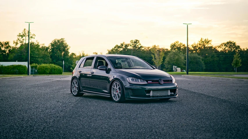 a gray volkswagen golf r line parked in an empty parking lot