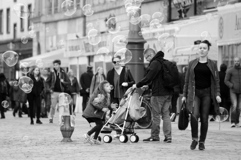 a woman and a man walk down a busy street with bubbles in the air