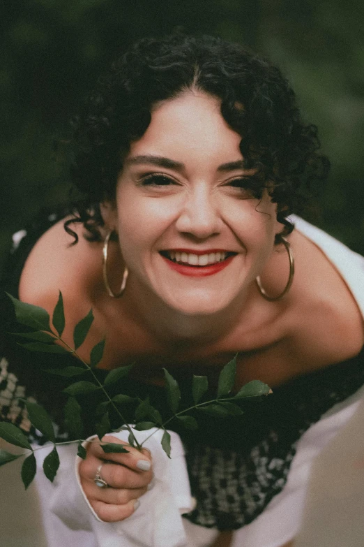 an attractive woman holding plants on her chest