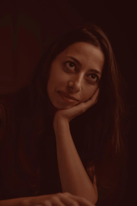 a woman holding her chin resting on a keyboard