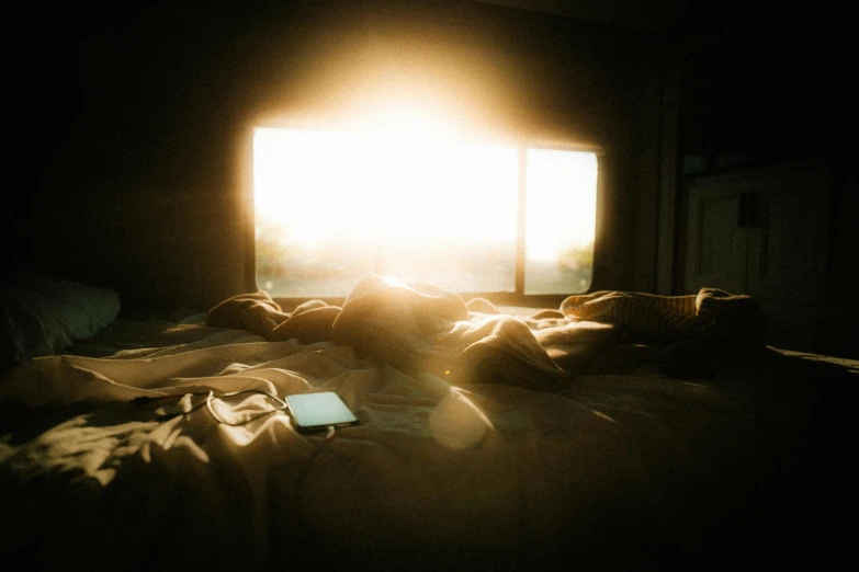 a bed with a blanket covering and a computer