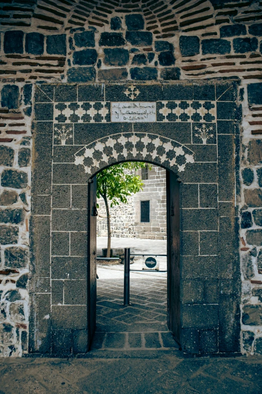 an arch is made from old brick to open up the gate