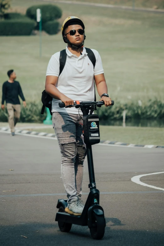 man in helmet on the street on a black scooter