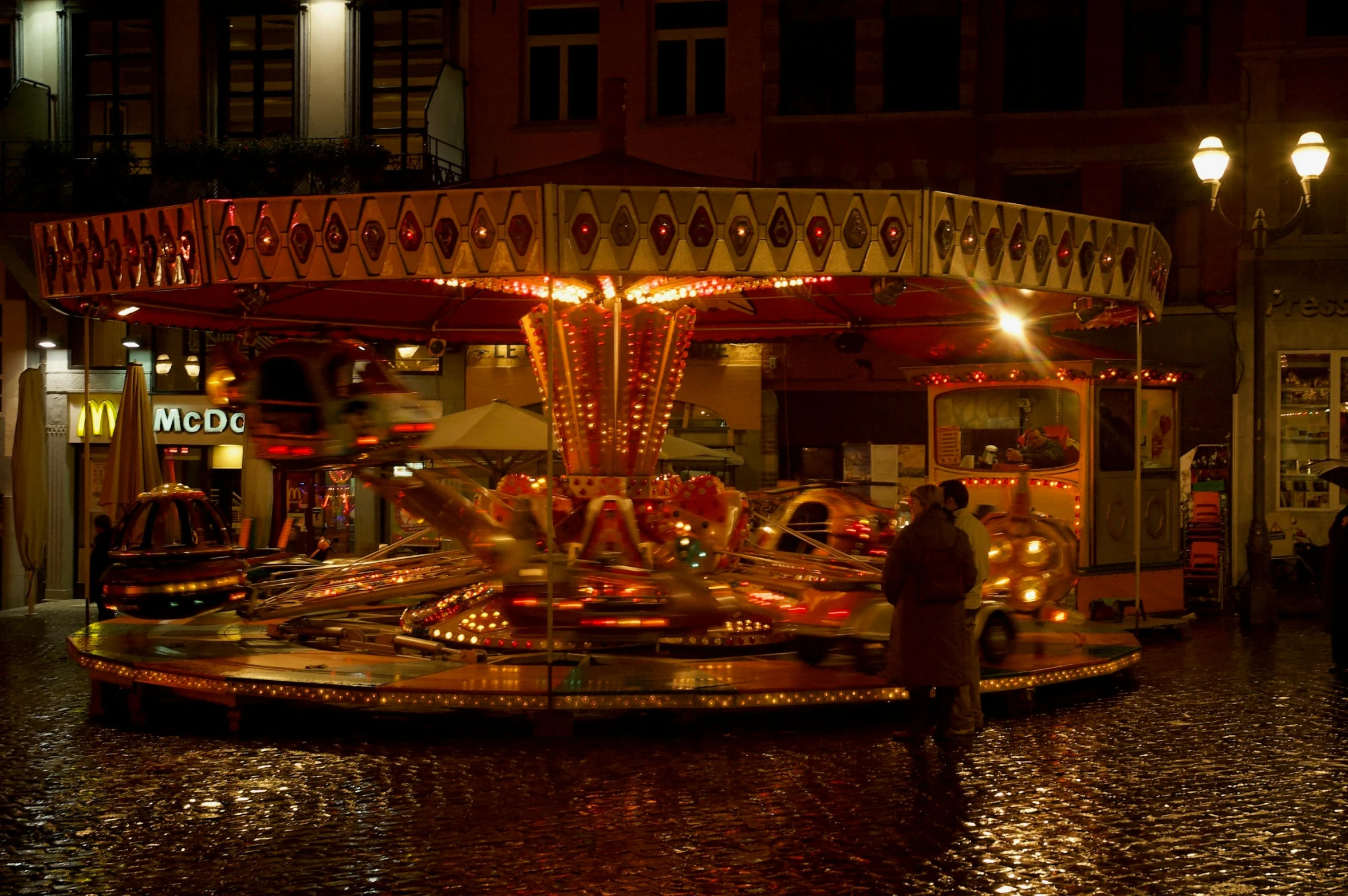 people enjoying the fun at a merry go round in the rain