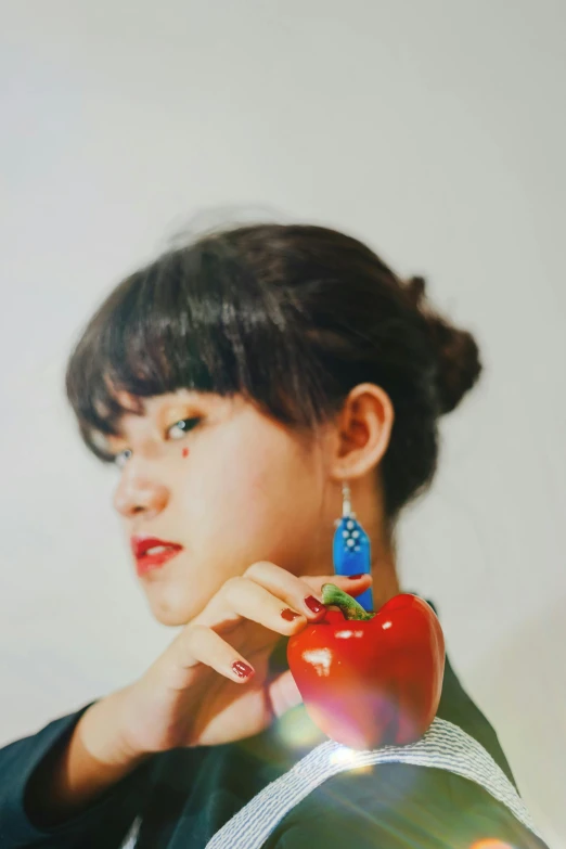 a woman holding an apple in front of her face