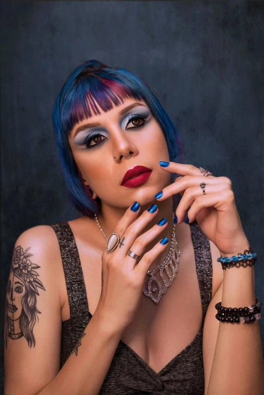 a woman with blue hair and tattoos smoking a cigarette