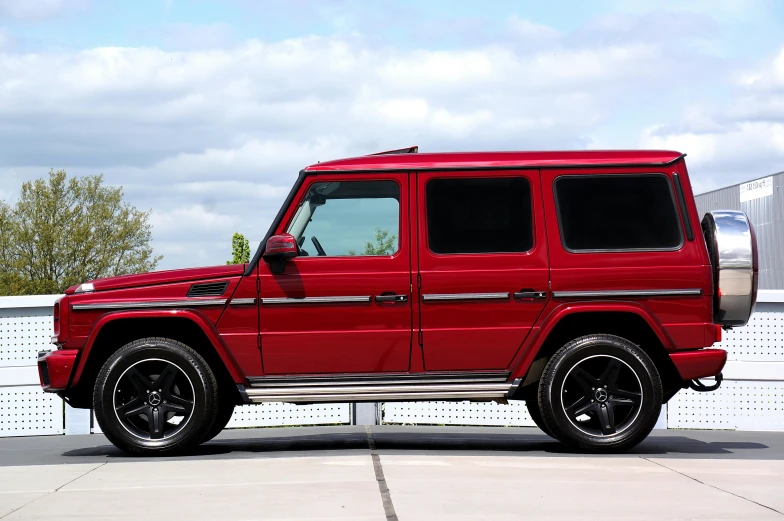 a red mercedes benz is parked in front of some buildings