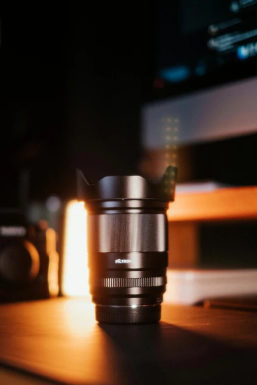 a lens sits on a table in front of a television