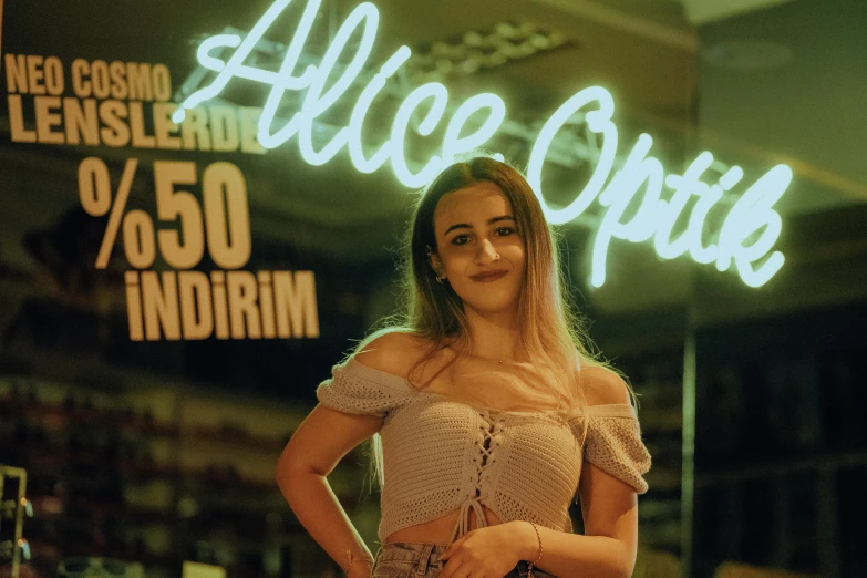 a smiling woman standing in front of a sign