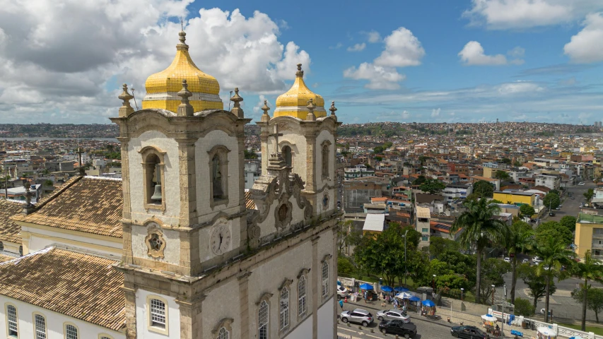 two tall buildings with yellow tops in a city