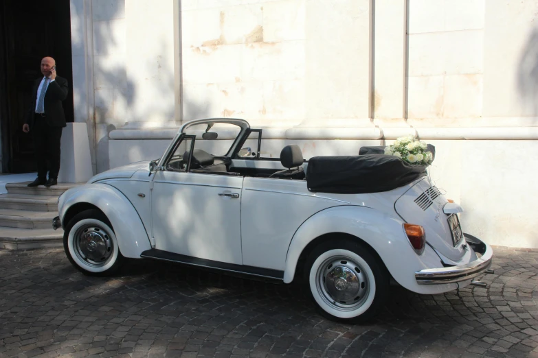 a classic white car with the passenger seat folded down