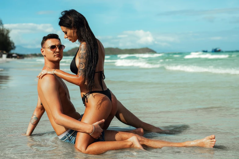 a woman laying on her chest in the ocean and a man