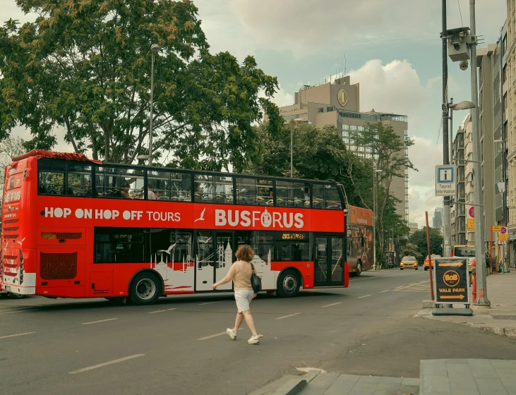 a red double decker bus drives down the street