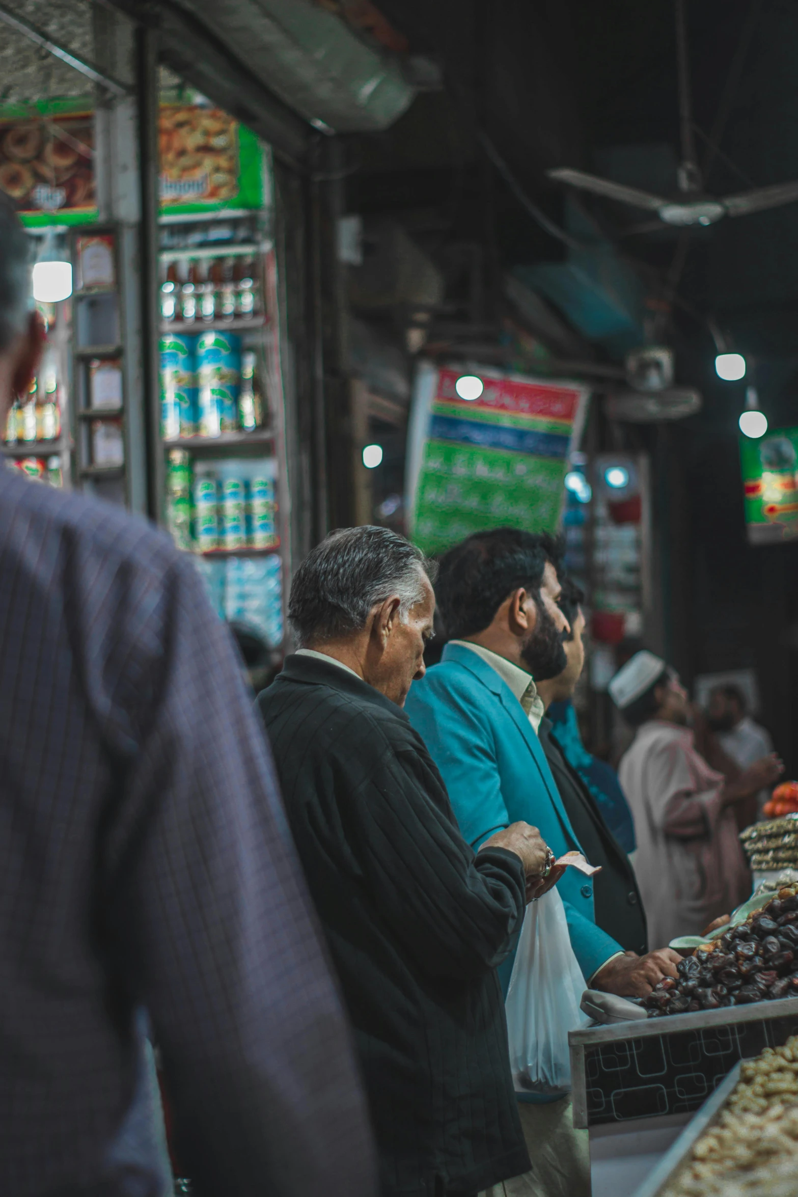 two men are standing together in front of the produce counter at a market