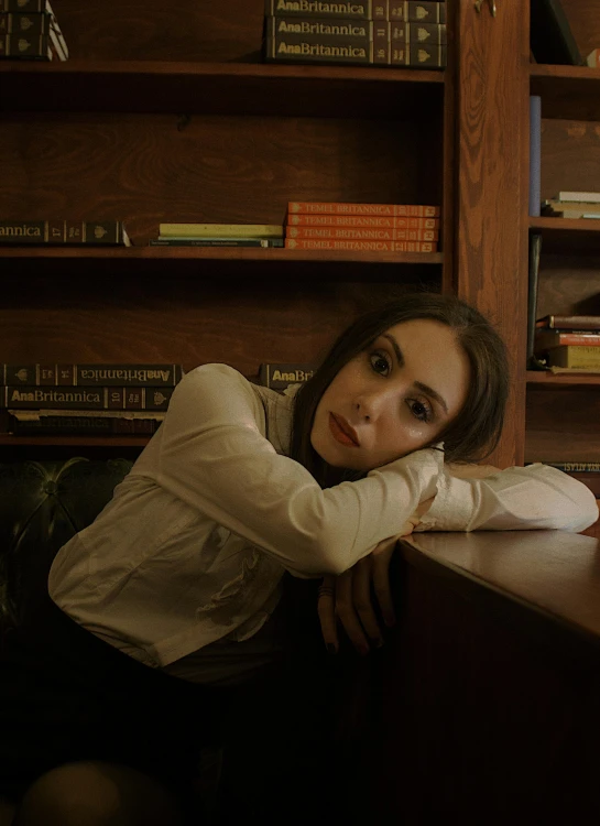 a woman sitting at a desk leaning over it