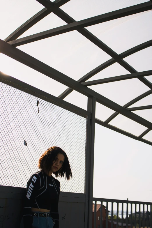 a young woman stands under a tarp near the ocean