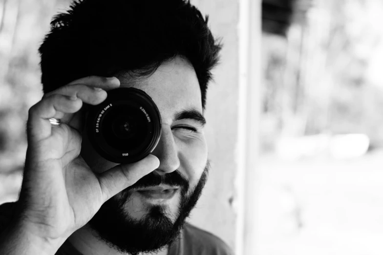 a man holding up a camera in front of his face