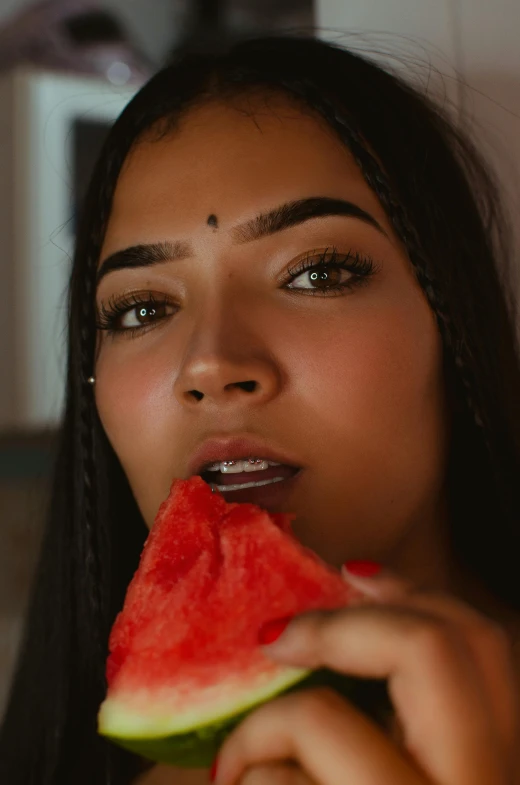 a girl biting into a piece of watermelon
