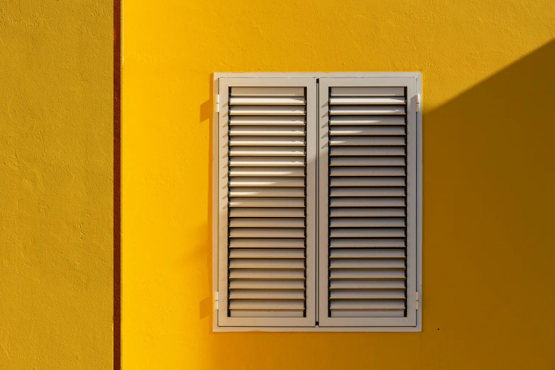 the shadow of an outside shutter on a wall