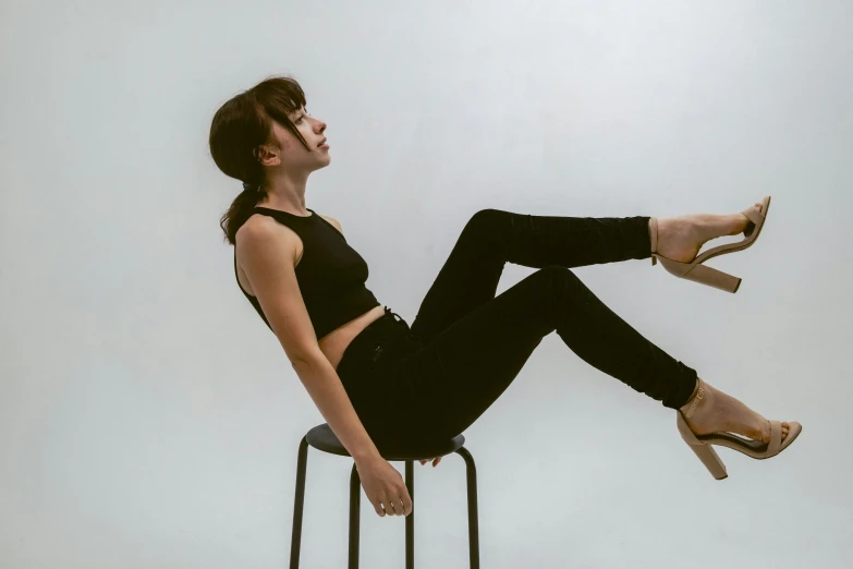 a woman is sitting on a chair with her legs crossed