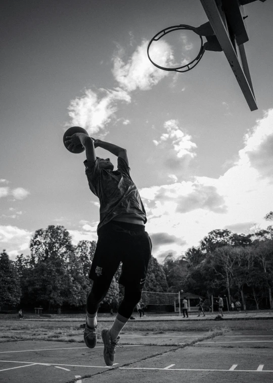 black and white pograph of a man on a basketball court with a hoop