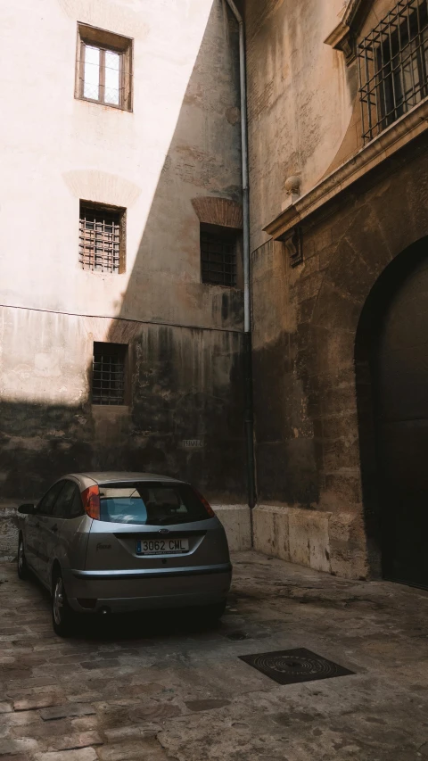 a car parked in a street by some stone buildings