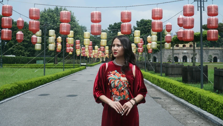 an asian woman in front of red lanterns