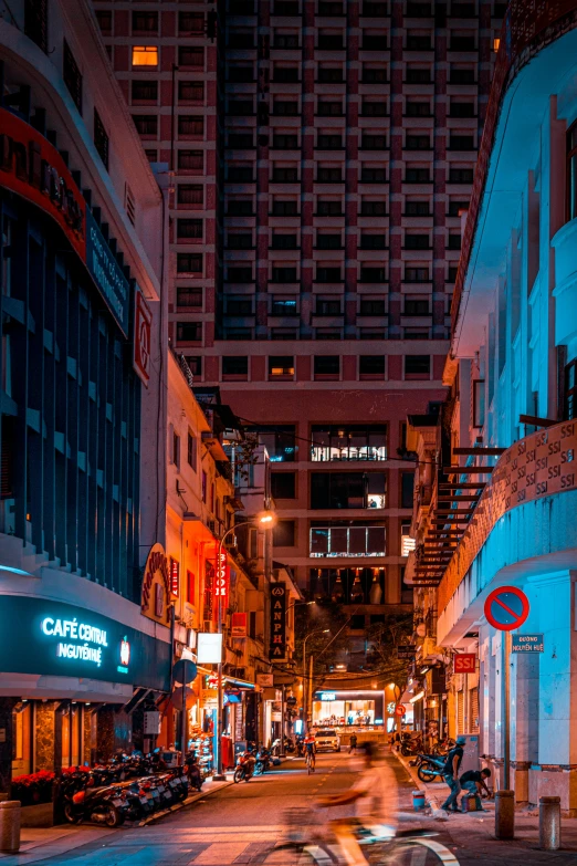 a blurry city street at night with a person on the motorcycle