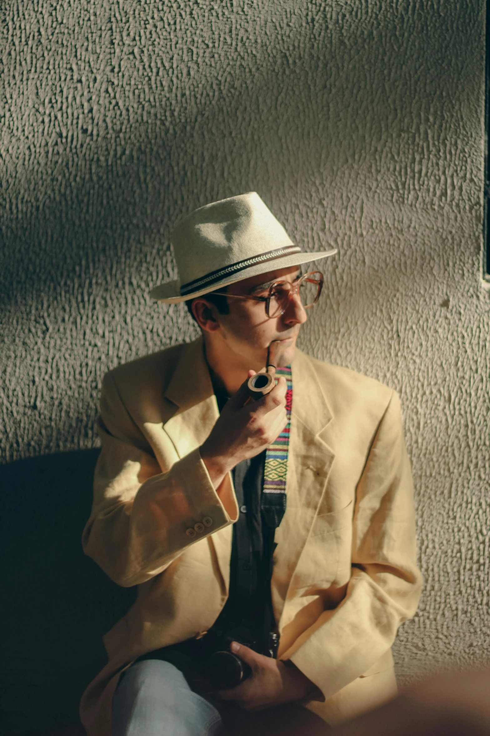 a man smoking a cigarette while wearing a suit