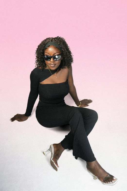 woman in black leotard on pink background with sunglasses