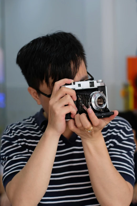 young man taking picture with camera using his hands