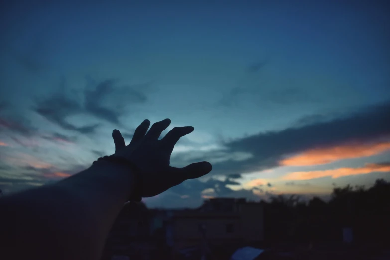 a person with their hands raised up in the sky