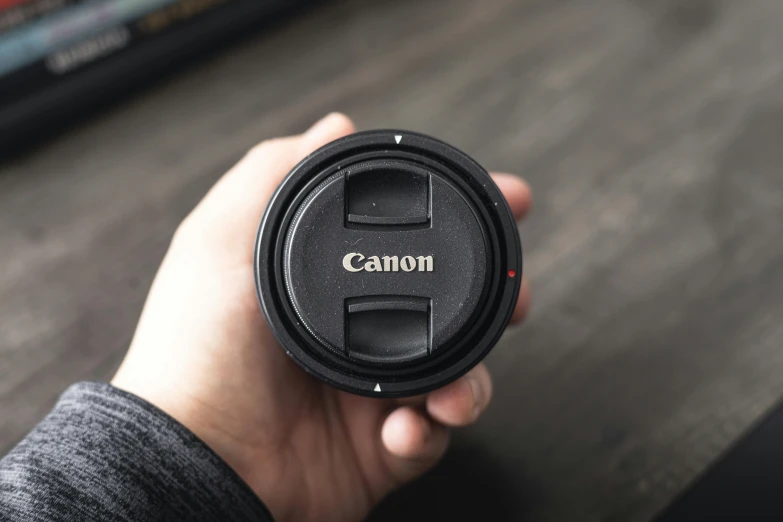 a camera lens is being held by someone's hand