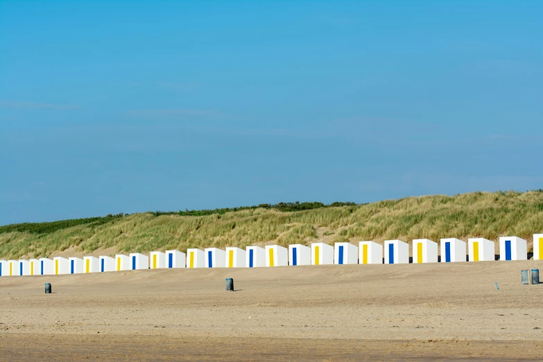 the beach is lined up and the buildings are painted bright yellow, blue and white