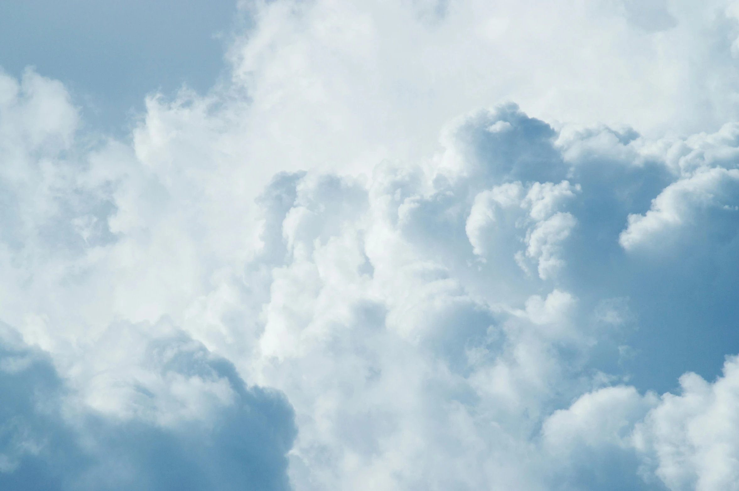 airplane flying thru the blue cloudy sky