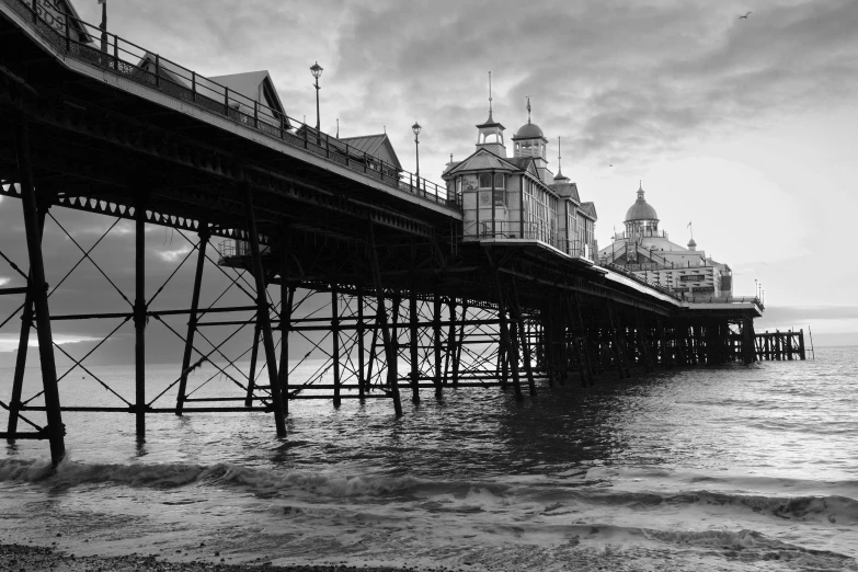 a black and white po of a pier at the beach