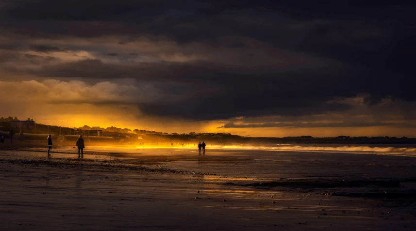 a person standing on the beach watching the sun go down