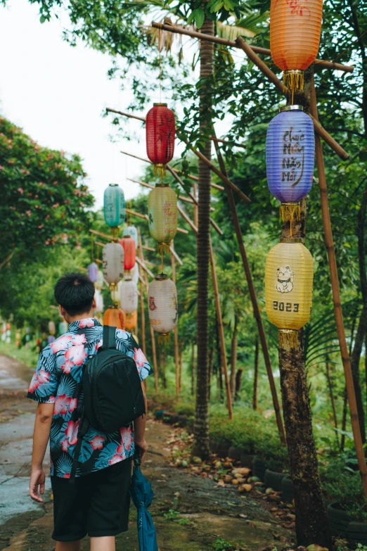 person walking along the road holding a back pack