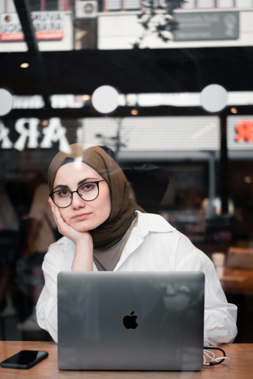 a woman sitting at a desk with her laptop computer