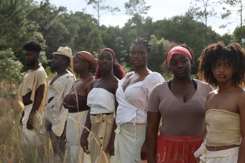 many young people standing on the side of a road