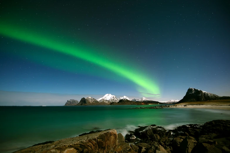 a green light over a mountain near water