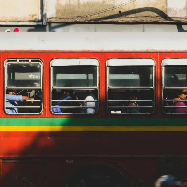 red and green bus with passengers inside